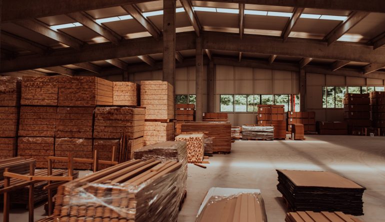 A vast warehouse in the forestry industry, showcasing a plethora of wooden products, including boards and various timber items neatly organized in storage.